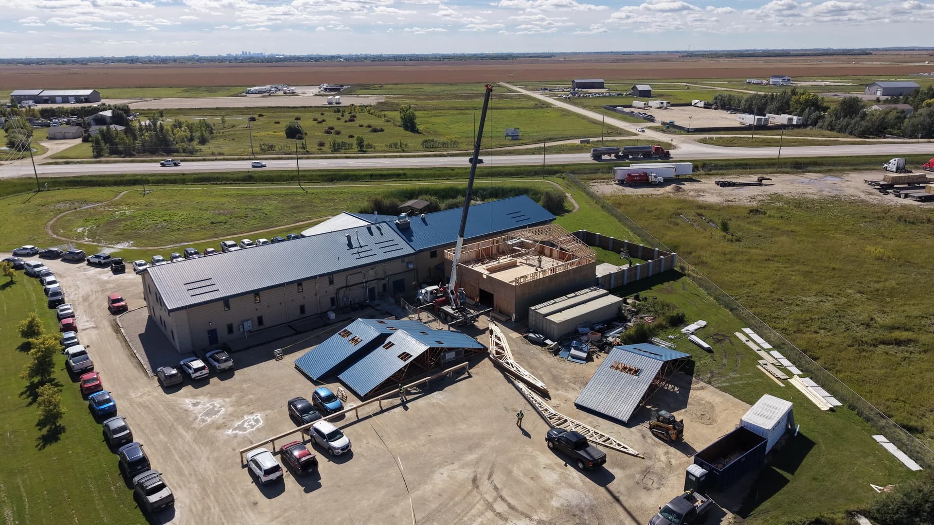 Aerial view of the Parsus Engineering office and vehicle garage renovation in St. Andrews, with a crane and roof framing work underway